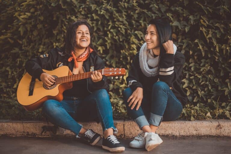 ragazzi peruviani che suonano una chitarra seduti in terra